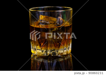 Glass of whiskey with ice on a black background Glass of whiskey with ice on a black background 90860231
