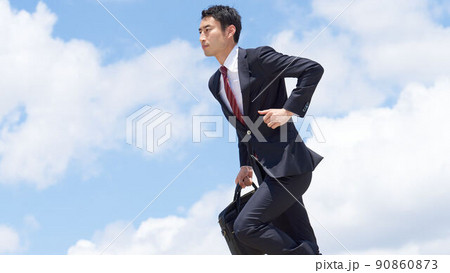 青空のもとで真剣な表情で走るビジネスパーソン 青空のもとで真剣な表情で走るビジネスパーソン 90860873