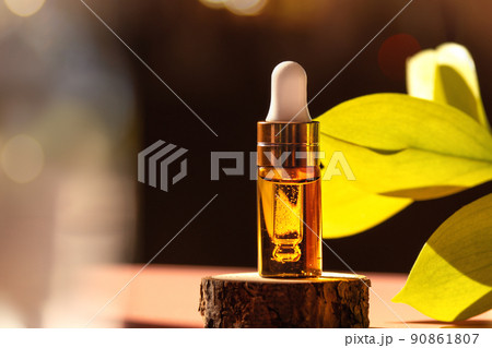Cosmetic amber glass dropper bottle on wooden podium with oil, serum or fruit peeling in the sunlight. Green ruscus, soft focus. Beauty product presentation, natural background. Front. Mockup concept Cosmetic amber glass dropper bottle on wooden podium with oil, serum or fruit peeling in the sunlight. Green ruscus, soft focus. Beauty product presentation, natural background. Front. Mockup concept 90861807