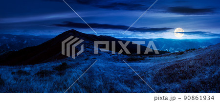 mountain landscape in early autumn at night. colorful scenery with peak and grassy hills in full moon light. ridge in the distance beneath a cloudy sky. travel destination concept 90861934