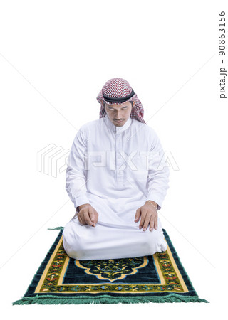 Muslim man with keffiyeh with agal in praying position (salat) on the prayer rug Muslim man with keffiyeh with agal in praying position (salat) on the prayer rug 90863156