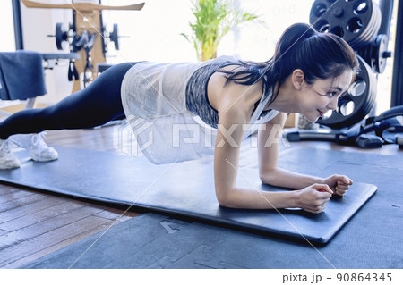スポーツジムでトレーニングをする若い女性 90864345