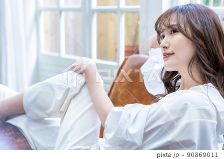 リビングのソファーでくつろぐ女性 90869011