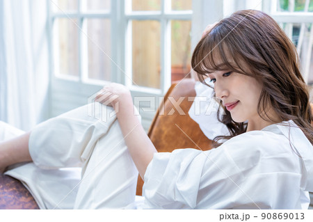 リビングのソファーでくつろぐ女性 90869013