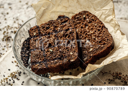 Organic wholegrain rye healthy bread with seeds in glass plate on baking paper. Healthy lifestyle concept 90870789