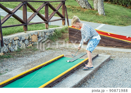 Boy plays mini golf on the territory of the hotel 90871988