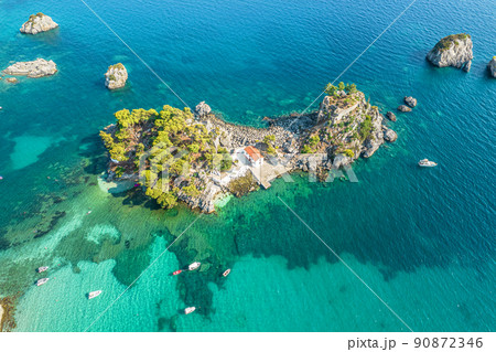 The island of Panagia with church located right in front of the port of Parga among in blue, turquoise sea water. Aerial, top, drone view. Greece 90872346