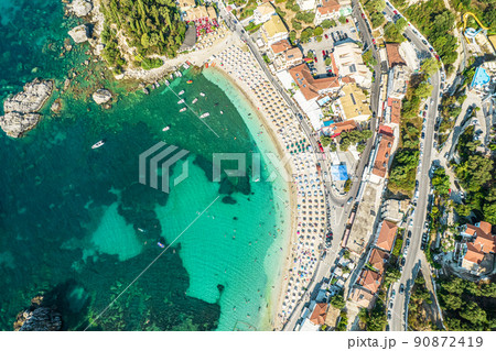 Beautiful colorful houses of seaside town, port of Parga with boats, cruise ship. Sand beach with umbrellas, tourist people, blue, turquoise sea water. Summer vacations and travel concept. Greece. 90872419