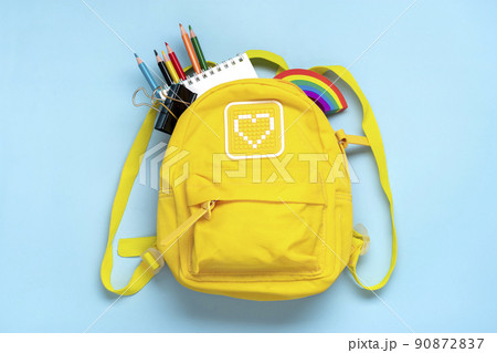 Back to school, education concept Yellow backpack with school supplies - notebook, pens, eraser rainbow, numbers isolated on blue background Top view Copy space Flat lay composition. Back to school, education concept Yellow backpack with school supplies - notebook, pens, eraser rainbow, numbers isolated on blue background Top view Copy space Flat lay composition. 90872837