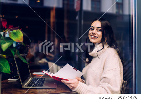 Smiling woman working using notebook in cafe 90874476