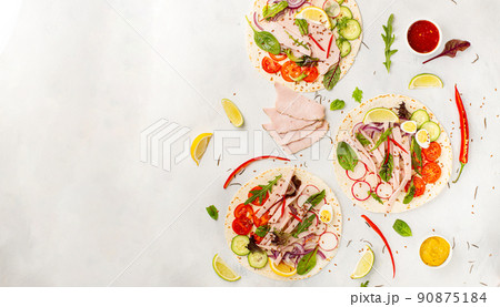 Corn tortillas with ham, tomatoes, fresh herbs, on white wooden table, top view. Food concept. mexican tacos 90875184