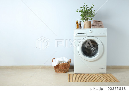 Concept of housework with washing machine against white wall Concept of housework with washing machine against white wall 90875818