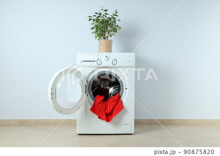 Concept of housework with washing machine against white wall 90875820