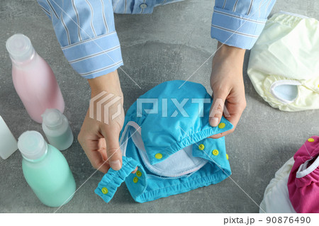Concept of baby clothes with reusable diapers on gray textured background Concept of baby clothes with reusable diapers on gray textured background 90876490