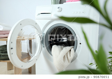 Concept of housework with washing machine against white wall 90876651
