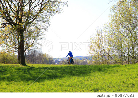 Regensburg, Germany, people are riding the bike on a rural road at sunset along Danube river in Regensburg, Germany, Europe. Regensburg, Germany, people are riding the bike on a rural road at sunset along Danube river in Regensburg, Germany, Europe. 90877633