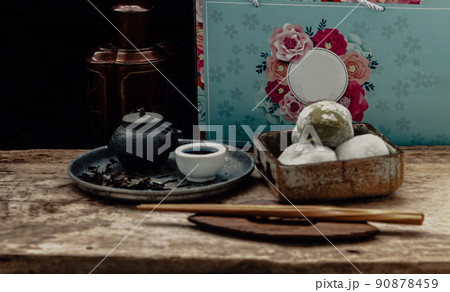 Green tea and Red bean daifuku with chinese tea on old wooden background. Green tea and Red bean daifuku with chinese tea on old wooden background. 90878459