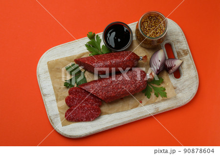 Concept of tasty food with salami sausage on orange background 90878604