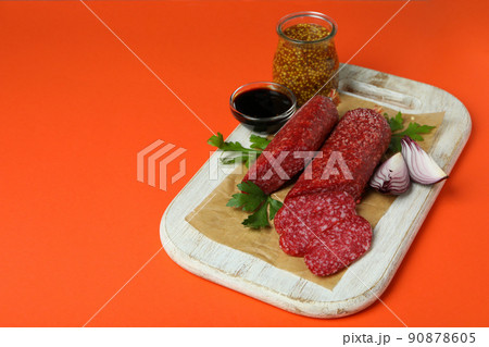Concept of tasty food with salami sausage on orange background 90878605