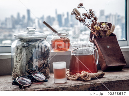 Refreshing with Chinese herbal tea (Jub Lieng) served with honey on old wooden table with city view. 90878657