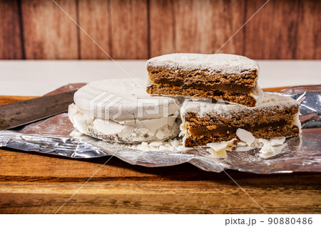 Typical Argentinean white alfajores filled with dulce de leche and covered with a hard glaze coating. Traditional sweet food. 90880486