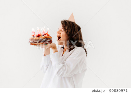 a happy woman with a birthday cake with candles. a happy woman with a birthday cake with candles. 90880971