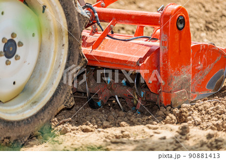 Cultivator for a mini-tractor for loosening the soil. Agricultural work. Excavation. Close-up Cultivator for a mini-tractor for loosening the soil. Agricultural work. Excavation. Close-up 90881413