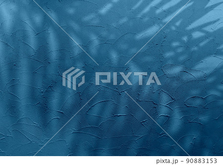 コテ塗りで仕上げたチョークブルーの壁と、トロピカルなヤシの葉シルエット 90883153