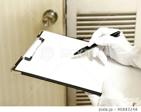 ドアを査定するクリップボードを持った白手袋の手元 90883248