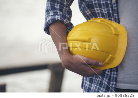 Engineer man hands holding hardhat white work helmet hard hat for Civil Construction Engineering. Construction engineer man in safety suit hold white work helmet hard hat on hands at Construction Site Engineer man hands holding hardhat white work helmet hard hat for Civil Construction Engineering. Construction engineer man in safety suit hold white work helmet hard hat on hands at Construction Site 90886528
