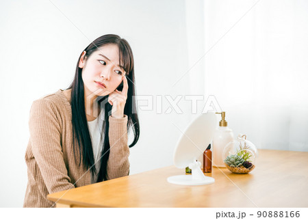 鏡の前で肌に悩む女性（目・目尻） 90888166
