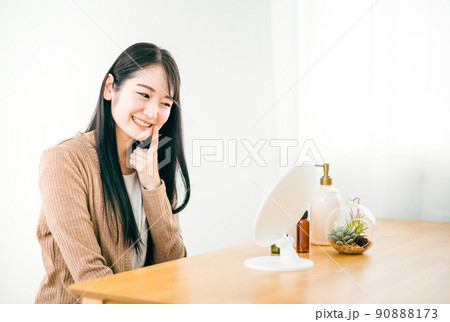 部屋で鏡を見る肌荒れが治った女性(笑顔・ほうれい線) 部屋で鏡を見る肌荒れが治った女性(笑顔・ほうれい線) 90888173