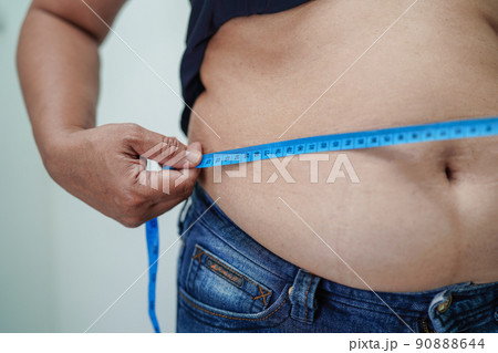 Asian woman show fat belly big size overweight and obesity at office. 90888644