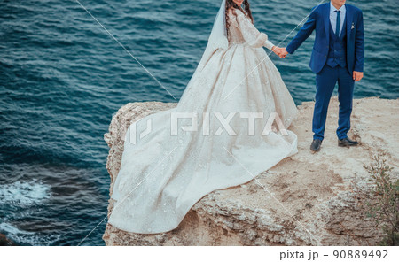 Details of the bride dress fabric and beautiful embroidery wedding concept used as a background for illustrations and text. Close-up image of part of the white luxury bridal dress. 90889492