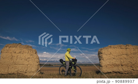 The man travel on mixed terrain cycle touring with bikepacking. The traveler journey with bicycle bags. Sport tourism bikepacking. 90889937