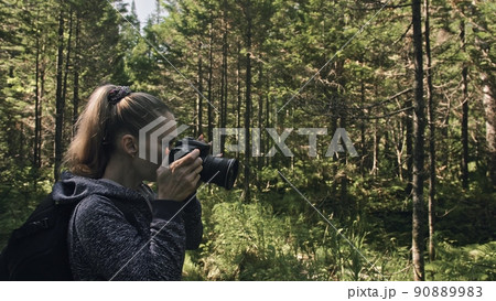 Traveler photographing scenic view in forest. One caucasian woman shooting nice magic look. Girl take photo video on dslr mirrorless camera. Traveler photographing scenic view in forest. One caucasian woman shooting nice magic look. Girl take photo video on dslr mirrorless camera. 90889983