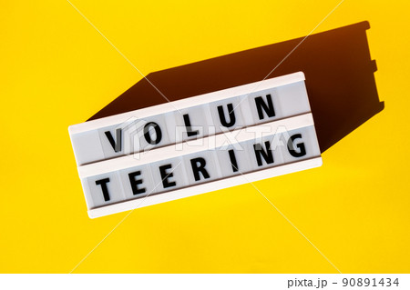 Lightbox with text VOLUNTEERING. Motivational Words Quotes Concept. Colorful yellow background. Minimalistic creative concept. Lightbox with text VOLUNTEERING. Motivational Words Quotes Concept. Colorful yellow background. Minimalistic creative concept. 90891434