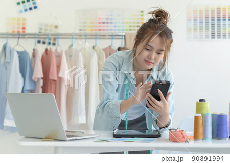 Young woman designer clothing, clothing designer workspace, clothing design accessories. 90891994