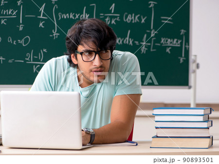 Young male student mathematician in front of chalkboard 90893501