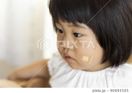 頬に絆創膏を貼った赤ちゃん（女の子、日本人、1歳11ヶ月） 90893585
