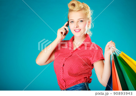 Pinup girl with shopping bags calling on phone 90893943