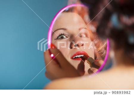 Girl applying make up red lipstick Girl applying make up red lipstick 90893982