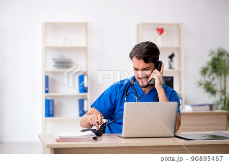 Young male doctor in telemedicine concept Young male doctor in telemedicine concept 90895467