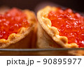 Salmon caviar in a tartlet on a glass dish. Festive table setting 90895977