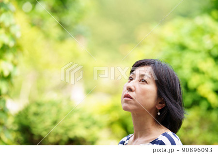 緑の中で真顔の中年女性 考え事をする女性 緑の中で真顔の中年女性 考え事をする女性 90896093