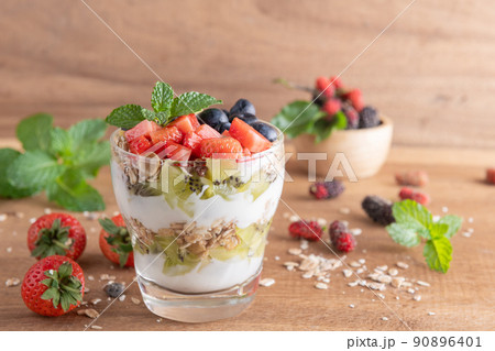 Homemade muesli, bowl of oat granola with yogurt, fresh blueberries, mulberry, strawberries, kiwi, mint and nuts board for healthy breakfast, copy space. Healthy breakfast concept. Clean eating. Homemade muesli, bowl of oat granola with yogurt, fresh blueberries, mulberry, strawberries, kiwi, mint and nuts board for healthy breakfast, copy space. Healthy breakfast concept. Clean eating. 90896401