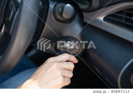 Closeup inside vehicle of hand holding key in ignition, start engine key, woman driver starting the car engine, the concept of buying a used car or a rental car. Closeup inside vehicle of hand holding key in ignition, start engine key, woman driver starting the car engine, the concept of buying a used car or a rental car. 90897212