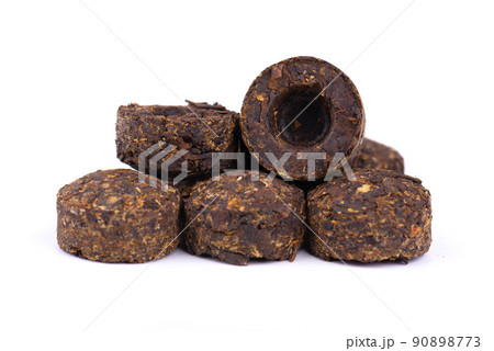 Puer tea isolated on white background. Close up. Fermented and compressed tea leaves. Round flat disc of puer tea. 90898773
