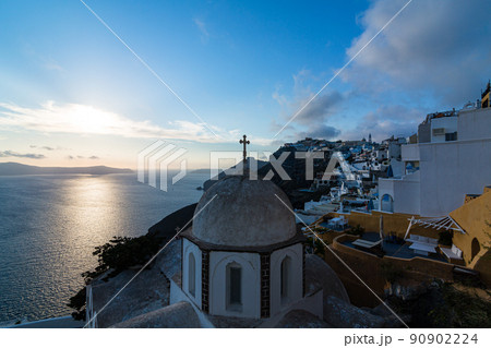 ギリシャ　サントリーニ島のフィラにある聖イオアニス・テオロゴス教会から見える街並みと夕日 90902224