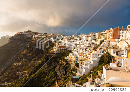 ギリシャ　サントリーニ島の崖の上にある夕陽で照らされたフィラの街並み 90902325